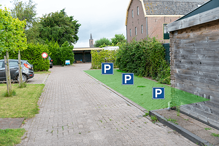 Parkerenplekken langs de groene schutting met klimplanten